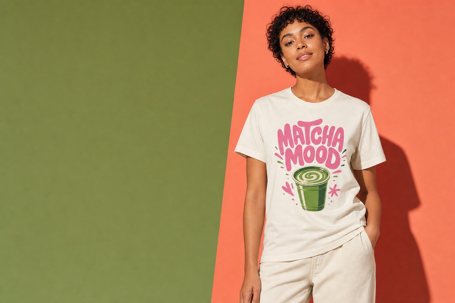 Model wearing the cream Matcha Mood t-shirt against green and coral colour blocks